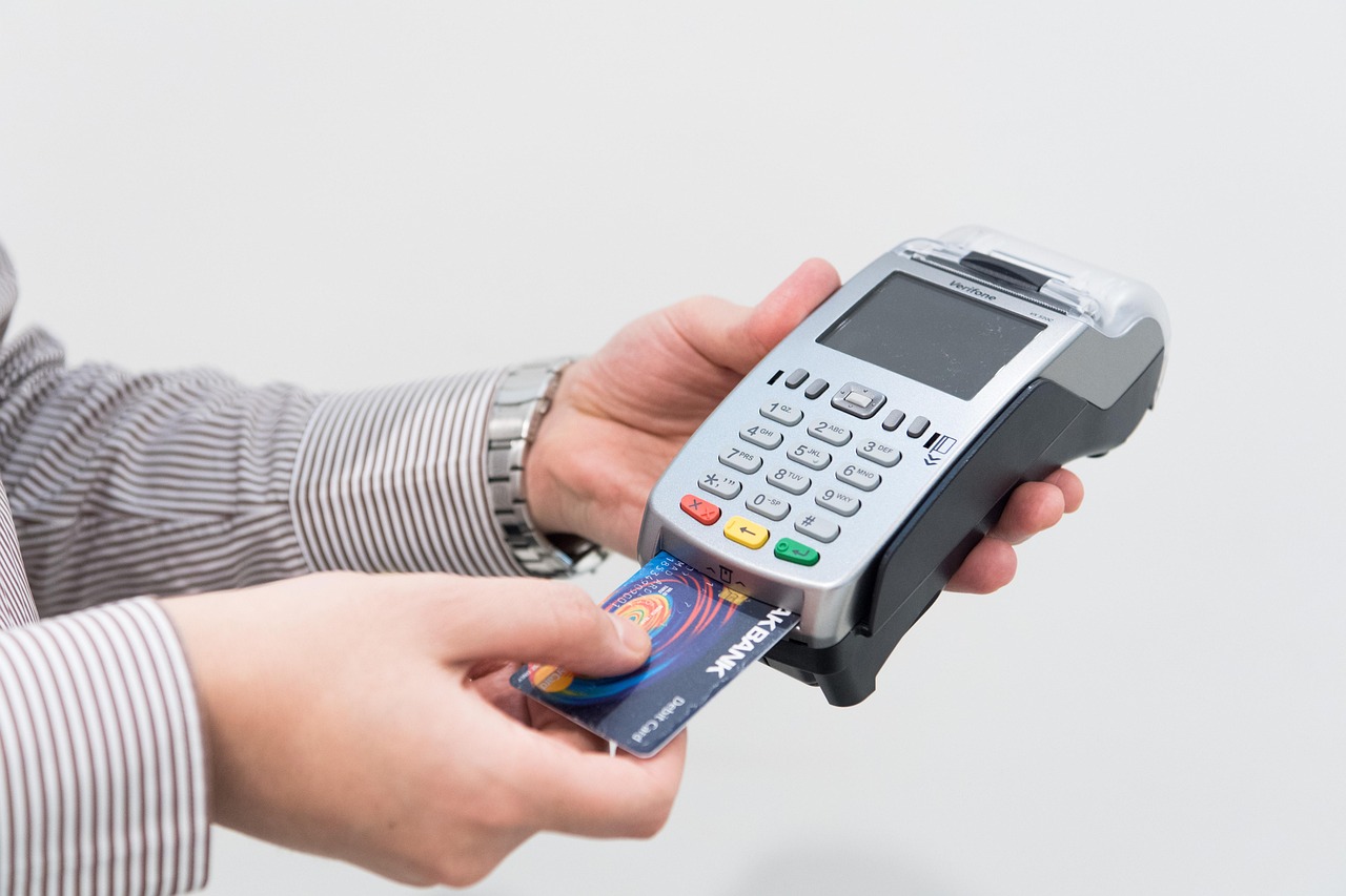 Retail assistant serving a customer at an EPOS checkout counter